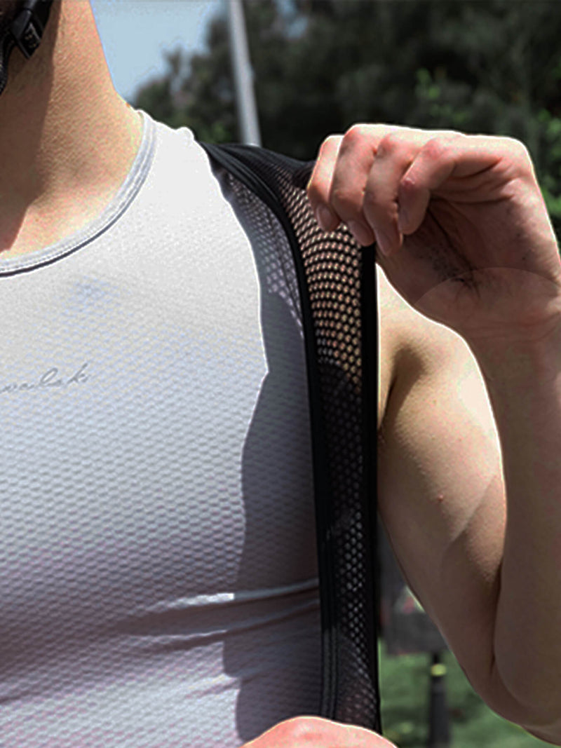 Black cycling bib shorts mesh shoulder panel being adjusted by hand